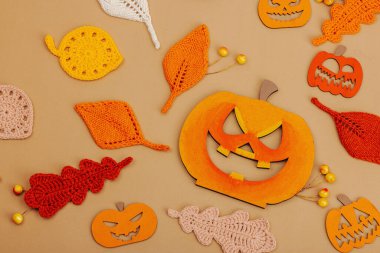 El yapımı sonbahar arkaplanı. Farklı düşme şekilleri, örülmüş yapraklar ve ahşap balkabakları. El işi, hobi konsepti, açık bej arka plan geleneksel dekor, üst görünüm