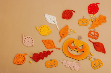 El yapımı sonbahar arkaplanı. Farklı düşme şekilleri, örülmüş yapraklar ve ahşap balkabakları. El işi, hobi konsepti, açık bej arka plan geleneksel dekor, üst görünüm