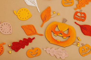 El yapımı sonbahar arkaplanı. Farklı düşme şekilleri, örülmüş yapraklar ve ahşap balkabakları. El işi, hobi konsepti, açık bej arka plan geleneksel dekor, üst görünüm