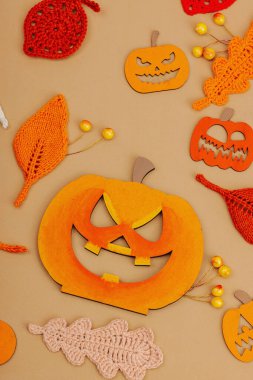 El yapımı sonbahar arkaplanı. Farklı düşme şekilleri, örülmüş yapraklar ve ahşap balkabakları. El işi, hobi konsepti, açık bej arka plan geleneksel dekor, üst görünüm