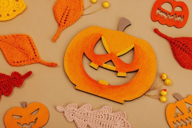 El yapımı sonbahar arkaplanı. Farklı düşme şekilleri, örülmüş yapraklar ve ahşap balkabakları. El işi, hobi konsepti, açık bej arka plan geleneksel dekor, üst görünüm