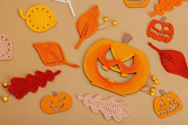 El yapımı sonbahar arkaplanı. Farklı düşme şekilleri, örülmüş yapraklar ve ahşap balkabakları. El işi, hobi konsepti, açık bej arka plan geleneksel dekor, üst görünüm