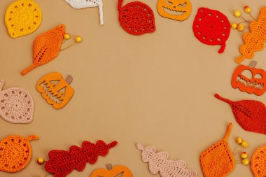 El yapımı sonbahar arkaplanı. Farklı düşme şekilleri, örülmüş yapraklar ve ahşap balkabakları. El işi, hobi konsepti, açık bej arka plan geleneksel dekor, üst görünüm