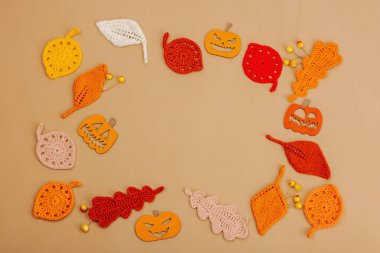 El yapımı sonbahar arkaplanı. Farklı düşme şekilleri, örülmüş yapraklar ve ahşap balkabakları. El işi, hobi konsepti, açık bej arka plan geleneksel dekor, üst görünüm