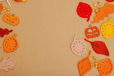 El yapımı sonbahar arkaplanı. Farklı düşme şekilleri, örülmüş yapraklar ve ahşap balkabakları. El işi, hobi konsepti, açık bej arka plan geleneksel dekor, üst görünüm