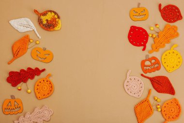 El yapımı sonbahar arkaplanı. Farklı düşme şekilleri, örülmüş yapraklar ve ahşap balkabakları. El işi, hobi konsepti, açık bej arka plan geleneksel dekor, üst görünüm