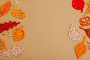 El yapımı sonbahar arkaplanı. Farklı düşme şekilleri, örülmüş yapraklar ve ahşap balkabakları. El işi, hobi konsepti, açık bej arka plan geleneksel dekor, üst görünüm