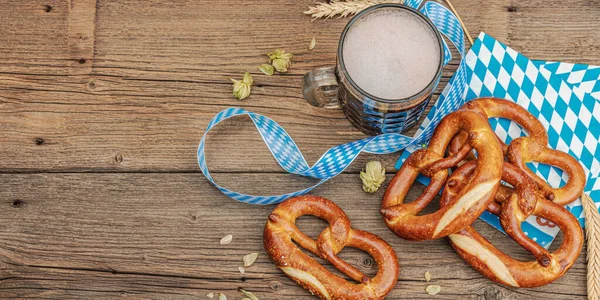 传统的Oktoberfest套装 椒盐和啤酒 德国节日食品的概念 流行的木制背景 横幅格式 图库图片