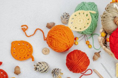 Örgü örmek için bir demet iplik. Tığ işi farklı yapraklar, el yapımı, sonbahar hobisi. Işık taşı arkaplan, üst görünüm üzerine dekorlar ve özel sanatlar araçları