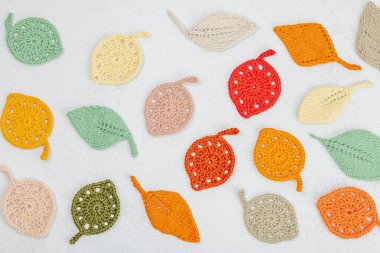 Örgü örmek için bir demet iplik. Tığ işi farklı yapraklar, el yapımı, sonbahar hobisi. Işık taşı arkaplan, üst görünüm üzerine dekorlar ve özel sanatlar araçları