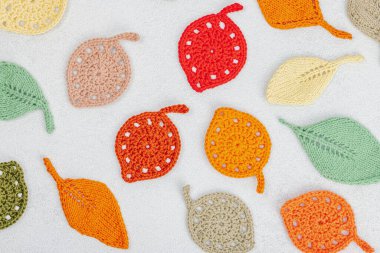 Örgü örmek için bir demet iplik. Tığ işi farklı yapraklar, el yapımı, sonbahar hobisi. Işık taşı arkaplan, üst görünüm üzerine dekorlar ve özel sanatlar araçları