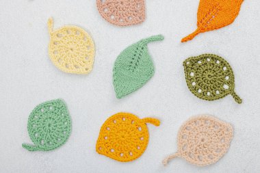 Örgü örmek için bir demet iplik. Tığ işi farklı yapraklar, el yapımı, sonbahar hobisi. Işık taşı arkaplan, üst görünüm üzerine dekorlar ve özel sanatlar araçları