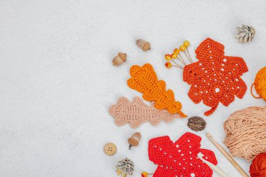 Örgü örmek için bir demet iplik. Tığ işi farklı yapraklar, el yapımı, sonbahar hobisi. Işık taşı arkaplan, üst görünüm üzerine dekorlar ve özel sanatlar araçları