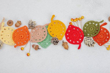 Örgü örmek için bir demet iplik. Tığ işi farklı yapraklar, el yapımı, sonbahar hobisi. Işık taşı arkaplan, üst görünüm üzerine dekorlar ve özel sanatlar araçları