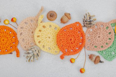 Örgü örmek için bir demet iplik. Tığ işi farklı yapraklar, el yapımı, sonbahar hobisi. Işık taşı arkaplan, üst görünüm üzerine dekorlar ve özel sanatlar araçları