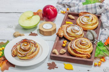 Elma güllü turta ve şeker tozu. Geleneksel sonbahar pişirme, sonbahar dekorasyonu, düz yatak. Sert ışık, karanlık gölge, ahşap arkaplan, kopyalama alanı