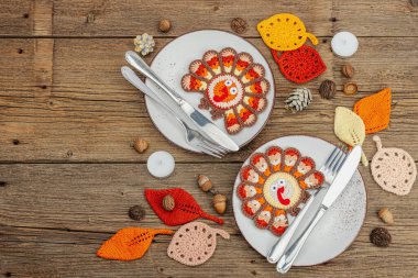 Sonbahar sofrası. Şükran Günü çatal bıçak takımı, geleneksel sonbahar dekorasyonu, düz yatış. Şenlik havası, el yapımı hindi ve yapraklar, ahşap arka plan, üst manzara.