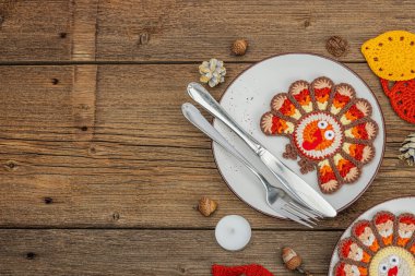 Sonbahar sofrası. Şükran Günü çatal bıçak takımı, geleneksel sonbahar dekorasyonu, düz yatış. Şenlik havası, el yapımı hindi ve yapraklar, ahşap arka plan, üst manzara.