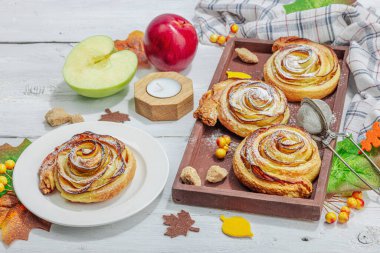 Elma güllü turta ve şeker tozu. Geleneksel sonbahar pişirme, sonbahar dekorasyonu, düz yatak. Sert ışık, karanlık gölge, ahşap arkaplan, kopyalama alanı