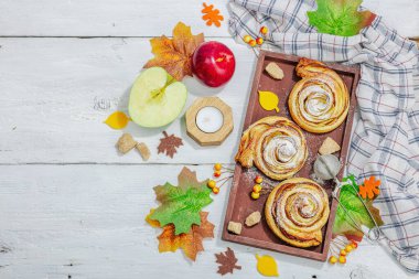 Elma güllü turta ve şeker tozu. Geleneksel sonbahar pişirme, sonbahar dekorasyonu, düz yatak. Sert ışık, karanlık gölge, ahşap arka plan, üst manzara