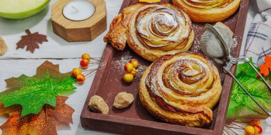 Elma güllü turta ve şeker tozu. Geleneksel sonbahar pişirme, sonbahar dekorasyonu, düz yatak. Sert ışık, koyu gölge, tahta arkaplan, pankart biçimi