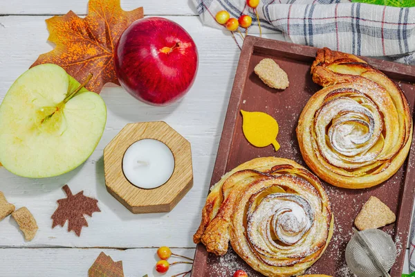 Elma güllü turta ve şeker tozu. Geleneksel sonbahar pişirme, sonbahar dekorasyonu, düz yatak. Sert ışık, karanlık gölge, ahşap arka plan, üst manzara