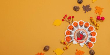 Sonbahar sofrası. Şükran Günü çatal bıçak takımı, geleneksel sonbahar dekorasyonu, düz yatış. Şenlik havası, el yapımı örgü örülmüş hindi ve yapraklar, sert ışık, koyu gölge, afiş biçimi