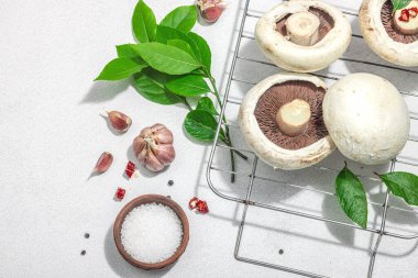 Bitki ve baharatlı taze portobello mantarı. Vejetaryen yemeği hazırlamak için sağlıklı bir malzeme. Sert ışık, karanlık gölge, taş beton zemin, üst manzara