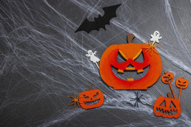 Cadılar Bayramı partisi için geleneksel festival kompozisyonu. Komik mevsimlik aksesuarlar, ev yapımı sonbahar dekorları. Sert ışık, karanlık gölge, siyah taş beton zemin, düz yatış, üst manzara