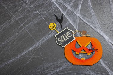 Satış konsepti, Cadılar Bayramı partisi için geleneksel festival kompozisyonu. Komik mevsimlik aksesuarlar, ev yapımı sonbahar dekorları. Sert ışık, karanlık gölge, siyah taş beton zemin, düz yatış, üst manzara