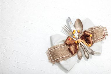 Sonbahar sofrası. Şükran Günü çatal bıçak takımı, geleneksel sonbahar dekorasyonu, düz yatış. Keyifli bir ortam, minimalist tasarım. Sert ışık, koyu gölge, beyaz macun arkaplan, üst görünüm