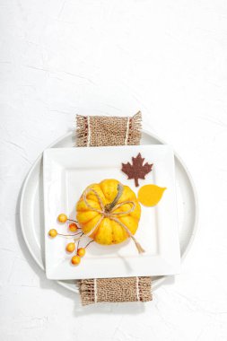 Sonbahar sofrası. Şükran Günü çatal bıçak takımı, geleneksel sonbahar dekorasyonu, düz yatış. Keyifli bir ortam, minimalist tasarım. Sert ışık, koyu gölge, beyaz macun arkaplan, üst görünüm