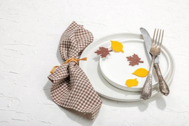 Sonbahar sofrası. Şükran Günü çatal bıçak takımı, geleneksel sonbahar dekorasyonu, düz yatış. Keyifli bir ortam, minimalist tasarım. Sert ışık, koyu gölge, beyaz macun arkaplanı, kopyalama alanı