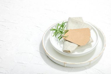 Minimalist masa düzeni. Zarif çatal bıçak takımı, geleneksel sıfır atık malzemesi, düz döşeme. Keyifli bir ortam, boş tabaklar. Sert ışık, koyu gölge, beyaz macun arkaplanı, kopyalama alanı