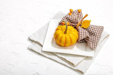 Sonbahar sofrası. Şükran Günü çatal bıçak takımı, geleneksel sonbahar dekorasyonu, düz yatış. Keyifli bir ortam, minimalist tasarım. Sert ışık, koyu gölge, beyaz macun arkaplanı, kopyalama alanı