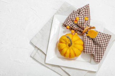 Sonbahar sofrası. Şükran Günü çatal bıçak takımı, geleneksel sonbahar dekorasyonu, düz yatış. Keyifli bir ortam, minimalist tasarım. Sert ışık, koyu gölge, beyaz macun arkaplan, üst görünüm