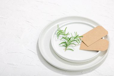 Minimalist masa düzeni. Zarif çatal bıçak takımı, geleneksel sıfır atık malzemesi, düz döşeme. Keyifli bir ortam, boş tabaklar. Sert ışık, koyu gölge, beyaz macun arkaplanı, kopyalama alanı
