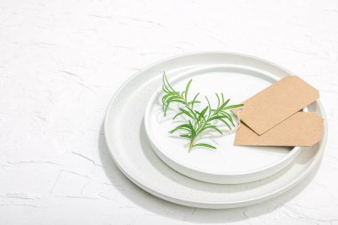 Minimalist masa düzeni. Zarif çatal bıçak takımı, geleneksel sıfır atık malzemesi, düz döşeme. Keyifli bir ortam, boş tabaklar. Sert ışık, koyu gölge, beyaz macun arkaplanı, kopyalama alanı