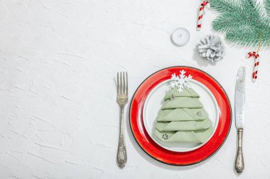 Noel sofrası. Yeni yıl çatal bıçak takımı, geleneksel kış dekorasyonu, düz yatak. Keyifli bir ortam, minimalist tasarım. Sert ışık, koyu gölge, beyaz macun arkaplan, üst görünüm