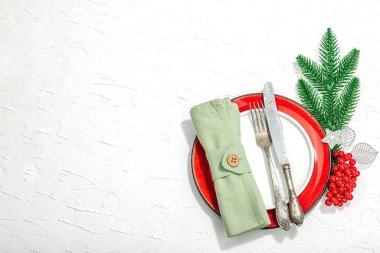 Noel sofrası. Yeni yıl çatal bıçak takımı, geleneksel kış dekorasyonu, düz yatak. Keyifli bir ortam, minimalist tasarım. Sert ışık, koyu gölge, beyaz macun arkaplan, üst görünüm