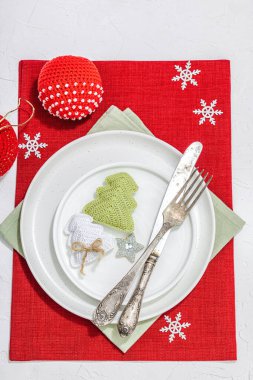 Noel sofrası. Yeni yıl çatal bıçak takımı, geleneksel kış dekorasyonu, düz yatak. Keyifli bir ortam, minimalist tasarım. Sert ışık, koyu gölge, beyaz macun arkaplan, üst görünüm