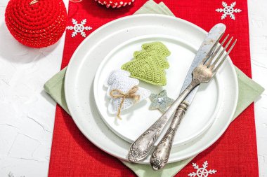 Noel sofrası. Yeni yıl çatal bıçak takımı, geleneksel kış dekorasyonu, düz yatak. Keyifli bir ortam, minimalist tasarım. Sert ışık, koyu gölge, beyaz macun arkaplanı, kopyalama alanı