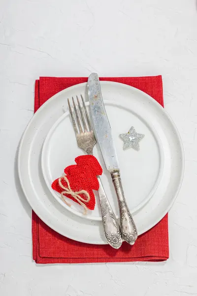 Christmas table setting. New Year cutlery, traditional winter decor, flat lay. Festive cozy mood, minimalist design. Hard light, dark shadow, white putty background, top view