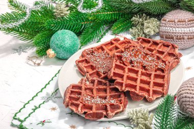 Çikolatalı Noel waffle 'ı. Yeni yıl kutlaması tatlısı, geleneksel düzenleme. Laktozsuz glüten pişirme, modaya uygun sert ışık, koyu gölge. Beyaz arkaplan, düz yatış, kopyalama alanı