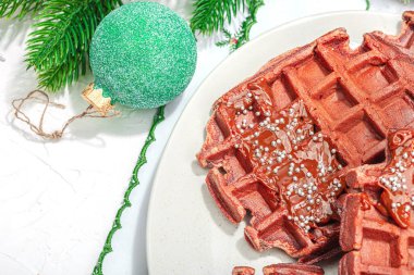 Çikolatalı Noel waffle 'ı. Yeni yıl kutlaması tatlısı, geleneksel düzenleme. Laktozsuz glüten pişirme, modaya uygun sert ışık, koyu gölge. Beyaz arkaplan, düz yatış, üst görünüm