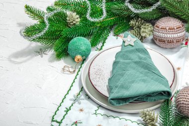 Noel sofrası. Yeni yıl çatal bıçak takımı, geleneksel kış dekorasyonu, düz yatak. Keyifli bir ortam, minimalist tasarım. Sert ışık, koyu gölge, beyaz macun arkaplanı, kopyalama alanı