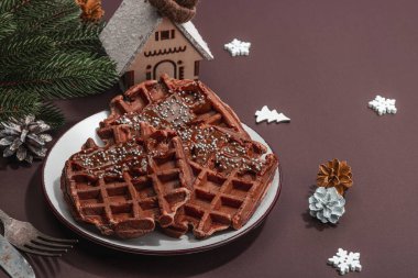 Çikolatalı Noel waffle 'ı. Yeni yıl kutlaması tatlısı, geleneksel düzenleme. Laktozsuz glüten pişirme, modaya uygun sert ışık, karanlık gölge, kopyalama alanı