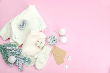 Sıcak kış kompozisyonu. Örgü eldivenler, sıcak eşarp, geleneksel Noel süsü, yeni yıl şenlik havası. Pembe zemin, düz yatış, üst görünüm