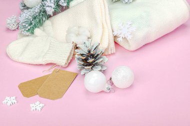 Sıcak kış kompozisyonu. Örgü eldivenler, sıcak eşarp, geleneksel Noel süsü, yeni yıl şenlik havası. Pembe arkaplan, düz yatış, kopyalama alanı