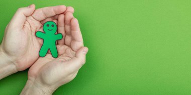 Dünya Akıl Sağlığı Günü. Erkek, kağıt adam figürlerini farklı duygularla tutuyor. Geri bildirim derecesi, müşteri değerlendirmesi, deneyim, memnuniyet anketi veya değerlendirme konsepti, düz uzanma